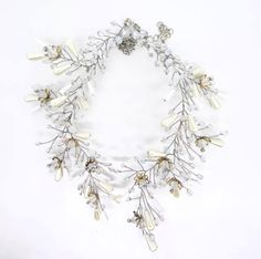 a necklace with pearls and leaves on it