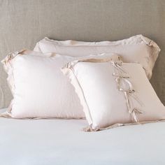 three white pillows sitting on top of a bed