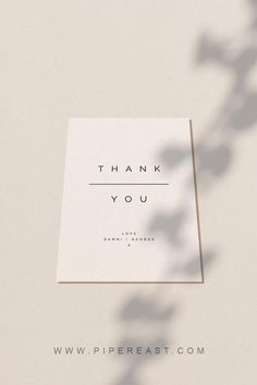 a thank you card sitting on top of a table next to a leafy plant