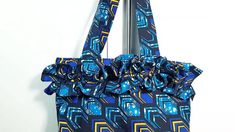 a handbag hanging on the wall with a blue and yellow print bow around it