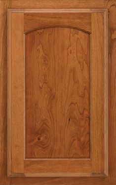 a close up view of a wooden door with wood grained panels and an arch in the center