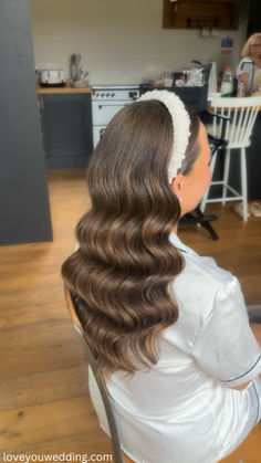 a woman sitting in a chair with her hair styled into a half - up style