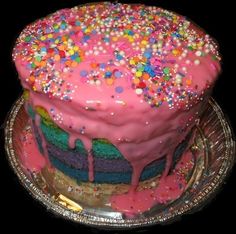 a cake that is covered in pink frosting and sprinkles