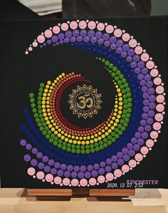 a painting with circles and dots in the shape of an omen symbol on a black background