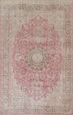 an antique rug with pink and brown colors