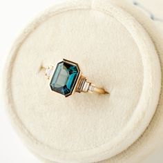 Why it's special: This Art Deco beauty features a captivating 3.05 carat teal sapphire, that we would say has the perfect color—a highly coveted deep blue-green that is unlike any other. This stunning gem will certainly not be repeated anytime soon. How many are available: Only one! This is a one-of-a-kind design. We won't find another sapphire exactly like this one! See this ring on a hand! DETAILS: Set with a 3.05 carat teal sapphire; heated and ethically sourced from Madagascar. Set with six Teal Sapphire Ring Nodeform, Beauty Features, Teal Sapphire, Green Sapphire, Baguette Diamond, Teal Green, Stacking Rings, Emerald Cut, Madagascar