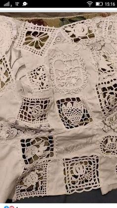 an old white crocheted table cloth with many small doily designs on it