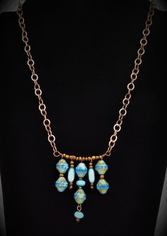 This necklace features beautiful Sky/Azure Blue etched picasso Czech glass beads with wonderful colors and detail.  Check out the 2nd picture which provides the best shot of the true colors on this handcrafted piece.  Bronze, light blue Cat's Eye beads, and baby blue czech rondelles are added and spaced across a bronze bar. The pendant is strung on medium sized cable style bronze chain.  The back features a hand made hammered hook which allows for length adjustability with the chain.  Back dangle finished this one-of-a-kind creation. Light Blue Single Strand Jewelry For Jewelry Making, Bohemian Blue Czech Glass Necklaces, Adjustable Czech Glass Artistic Jewelry, Blue Dangling Beads Pendant Jewelry, Artistic Jewelry With Dangling Beads For Gifts, Unique Blue Beaded Chain Necklaces, Adjustable Dangle Glass Necklace, Blue Pendant Jewelry With Dangling Beads, Artistic Blue Czech Glass Jewelry