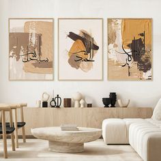 three paintings hang on the wall above a coffee table in a living room with white furniture