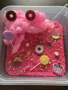 a plastic container filled with pink cake and donuts