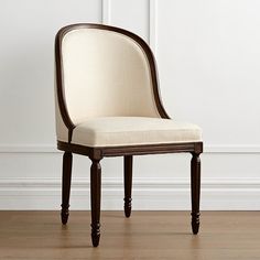 a chair sitting on top of a hard wood floor next to a white painted wall