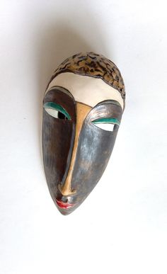 a wooden mask with green eyes on a white background