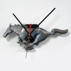 a clock with a silver horse running on it's side and red second hand