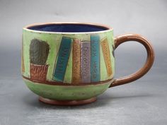 a ceramic mug with books on it sitting on a table