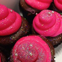 some pink frosted cupcakes with sprinkles on them