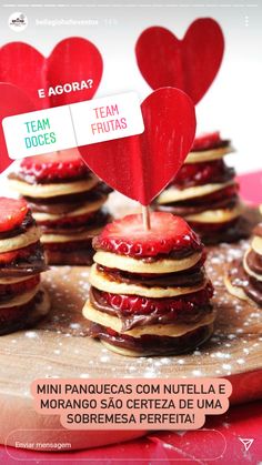 some heart shaped cookies are sitting on a cutting board with strawberries in the shape of hearts