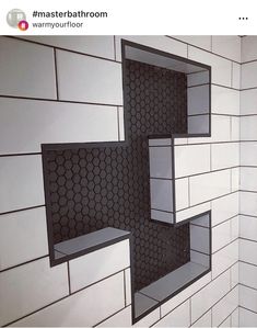 a bathroom with white and black tiles on the wall, two mirrors above the toilet