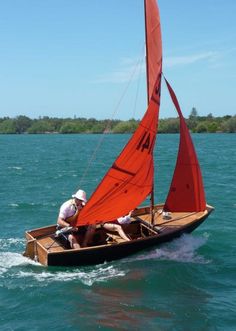 two people in a small sailboat on the water