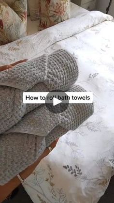 towels folded on top of a bed with the words how to roll bath towels