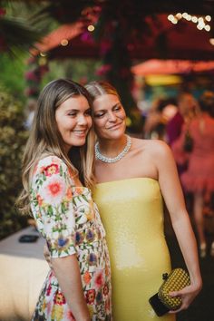 two women standing next to each other at a party