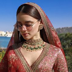 a woman in a red and gold bridal outfit