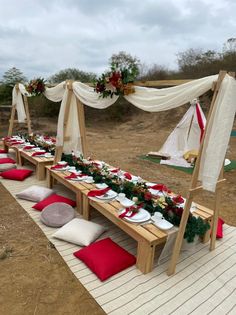 a long table set up with red and white pillows