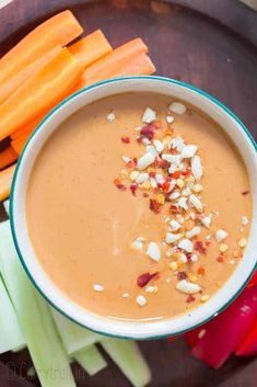 carrots and celery on a plate next to a bowl of creamy dip