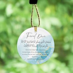 a glass ornament hanging from a rope with an arabic message on it's side