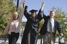 two men and a woman in graduation gowns holding their hands up to the sky