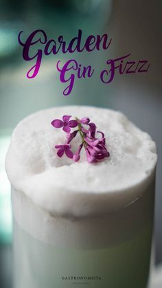 a close up of a drink with flowers on the top and text that reads garden gin fizz