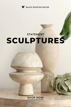 three white vases sitting on top of a wooden table next to a potted plant