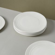 three white plates sitting on top of a table next to each other, with one empty plate in the middle