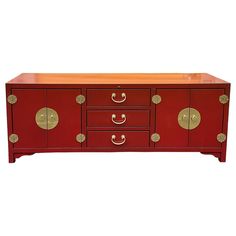 a red cabinet with gold handles and drawers