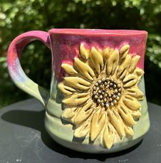 a ceramic coffee mug with a sunflower on it