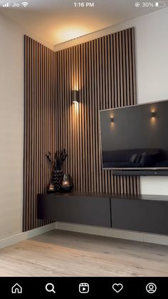 a flat screen tv sitting on top of a wooden shelf next to a wall mounted television