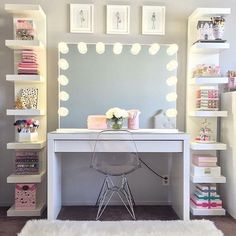 a white desk topped with a mirror next to a shelf filled with lots of books