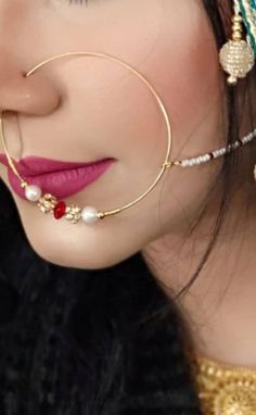 a close up of a woman with her nose ring and ear rings attached to her head