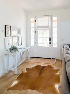 a living room filled with furniture and a cow skin rug