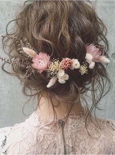 a woman with flowers in her hair is wearing a flower headpiece on the back of her head