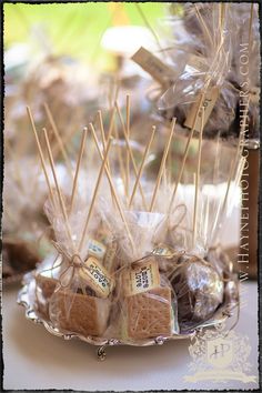 some cookies and marshmallows are on a silver platter with brown paper bags