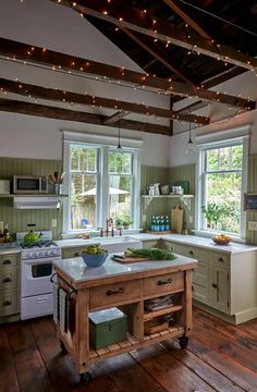 a kitchen with an island in the middle and lots of lights hanging from the ceiling