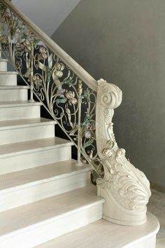 a white stair case with flowers painted on the side and handrails at the bottom