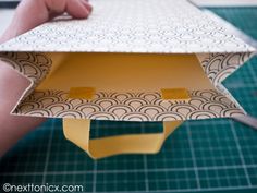 someone is cutting out an origami box with scissors