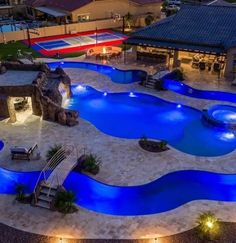 an aerial view of a swimming pool at night with lights on the sides and steps leading up to it