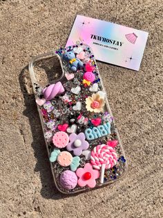 a phone case that has buttons and other things in it on the ground next to a business card