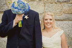 a bride and groom standing next to each other in front of a stone wall with a star on it