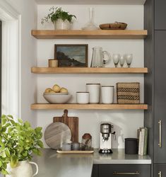 a kitchen with open shelving and wooden shelves