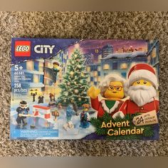 the lego city christmas calendar is laying on the floor next to it's box