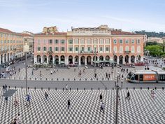 an aerial view of a city square with people walking around