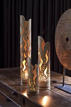 three decorative vases sitting on top of a wooden table